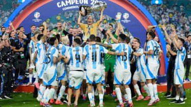 El equipador argentino Mario De Stefano sostiene el trofeo mientras celebra con los jugadores después de derrotar a Colombia en la final de la Copa América en Miami Gardens, Florida, el lunes 15 de julio de 2024.