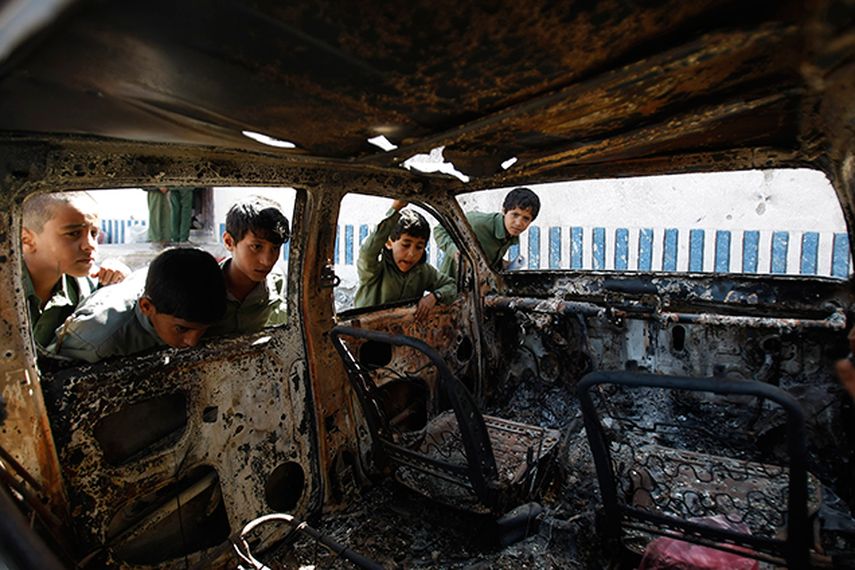 Niños yemeníes que observan un vehículo destruido durante un ataque a un bastión de al-Qaida al norte de Sanaa, Yemen. Al-Qaida se ha descentralizado, aunque no está en claro si la red terrorista se ha debilitado y si tiene menor capacidad como para la