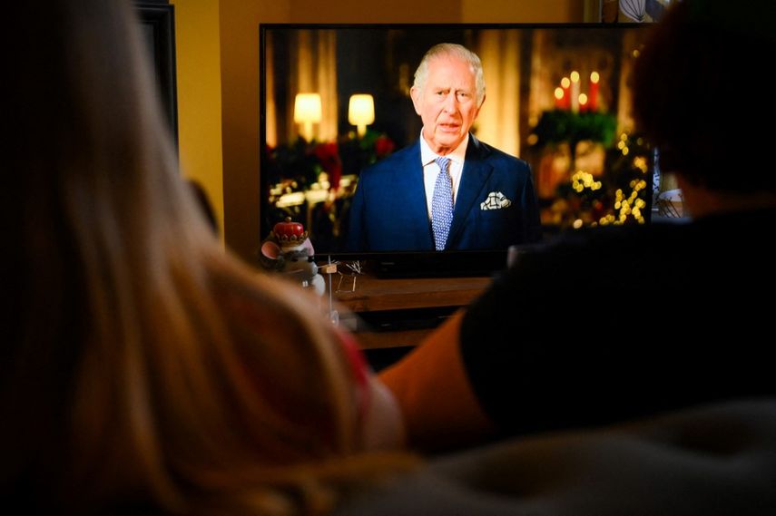 Una familia sentada en una sala de estar en Liverpool ven al rey Carlos III en su primer mensaje anual del día de Navidad, en la televisión, el 25 de diciembre de 2022.&nbsp;