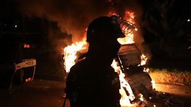 Un agente antimotines est&aacute; parado detr&aacute;s de una barricada en llamas durante las protestas por la muerte de un hombre a manos de la polic&iacute;a que lo detuvo por violar el distanciamiento social, en Bogot&aacute;,, 10 de septiembre de 2020.&nbsp;
