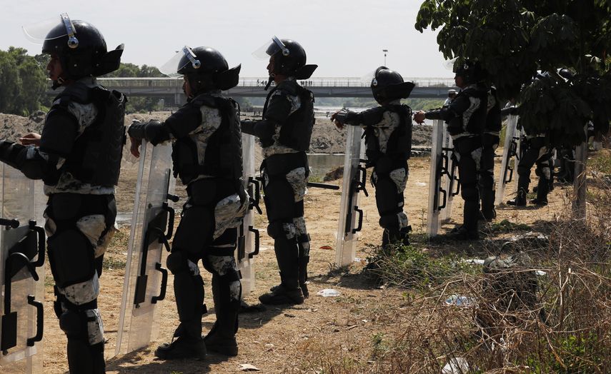 Efectivos de la Guardia Nacional permanecen en el lado mexicano de la orilla del r&iacute;o Suchiate cerca de Ciudad Hidalgo, M&eacute;xico, en la frontera con Guatemala, el martes 21 de enero de 2020, para impedir el paso a cientos de migrantes centroamericanos.