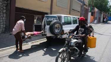 Personal paramédico levantan un cadáver en una calle de Puerto Príncipe, Haití.