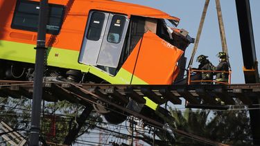 Bomberos trabajando para descolgar hasta el suelo un vagón de metro que quedó suspendido en un tramo elevado del metro, en Ciudad de México, el martes 4 de mayo de 2021. Al menos 24 personas murieron y más de 70 resultaron heridas tras el desplome de un paso elevado del metro.