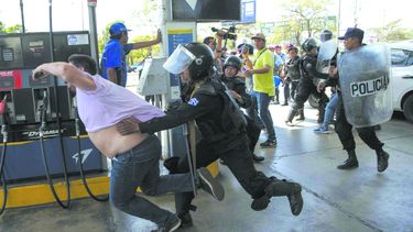 Policía Nacional de Nicaragua trata de detener al reportero gráfico Luis Sequeira, de la agencia AFP, durante una manifestación.