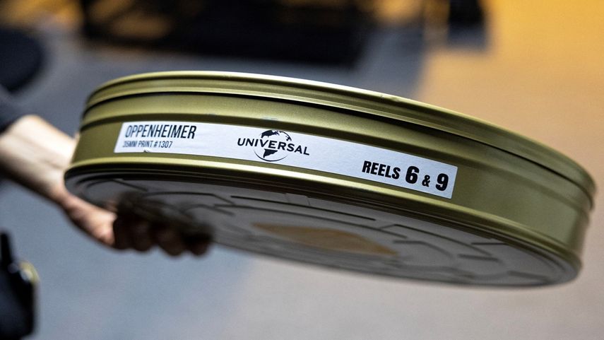 El proyeccionista Martín Ramírez sostiene una lata de película que contiene los carretes 6 y 9 de Oppenheimer, de Christopher Nolan, en la Cinemateca Uruguaya de Montevideo el 3 de agosto de 2023.