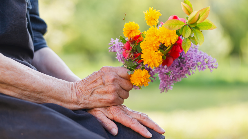 Una mujer acude al cementerio para llevar flores a su deudo.