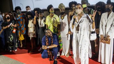 La actriz brasileña Tais Araujo habla mientras su esposo, el actor Lázaro Ramos, se sienta en cuclillas junto a ella antes de la vista previa de su película debut como director Medida Provisoria durante el Festival de Cine de Río de Janeiro el 15 de diciembre de 2021.