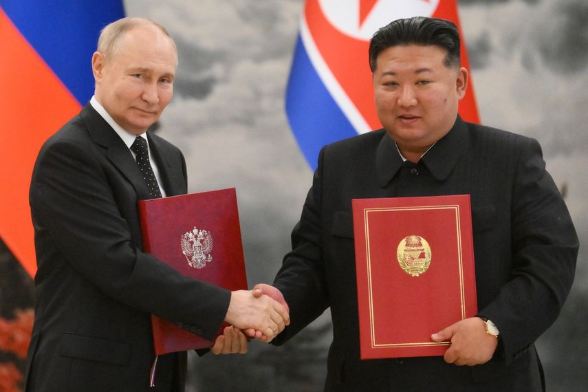 En esta fotografía de grupo distribuida por la agencia estatal rusa Sputnik, el presidente ruso Vladimir Putin (izq.) le da la mano al líder de Corea del Norte, Kim Jong Un (der.), después de una ceremonia de firma tras sus conversaciones bilaterales en la residencia estatal de Kumsusan en Pyongyang, el 19 de junio. 2024.