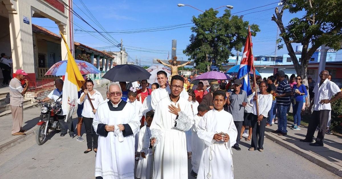 Sacerdote cubano desfila bajo banderas comunistas