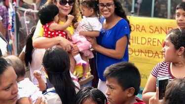 Fotografía cedida por Nora Sandigo Children Foundation donde aparece su directora ejecutiva Nora Sandigo mientras disfruta con niños en la gran fiesta navideña ofrecida por la fundación en Miami, Florida.