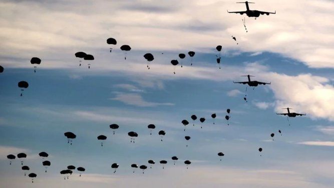 Paracaidistas de la 82 División Aerotransportada de Estados Unidos realizando un salto masivo desde unos C-17 Globemaster durante un ejercicio militar.
