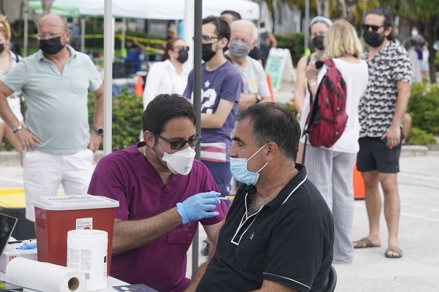Carlos Anacleto cierra los ojos mientras recibe la vacuna Pfizer COVID-19 de manos del enfermero Jorge Tase, mientras otros esperan su turno, el miércoles 4 de agosto de 2021 en Miami Beach, Florida.&nbsp;&nbsp;