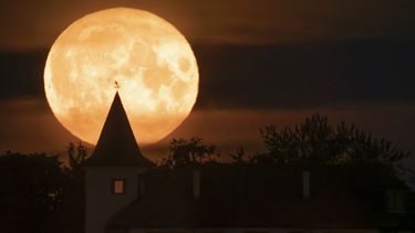 La luna lleva se eleva sobre una vivienda en la localidad de Putilovo, a 70 kilómetros (43 millas) al este de San Petersburgo, Rusia, el 13 de julio de 2022.&nbsp;