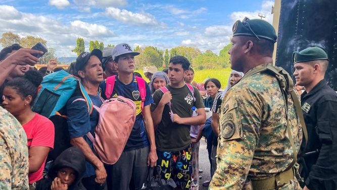 Migrantes hablan con miembros del Servicio Nacional de Fronteras de Panamá mientras intentan cruzar la frontera entre Panamá y Costa Rica mientras intentan regresar a Venezuela, en Paso Canoas entre la frontera de Panamá y Costa Rica el 11 de febrero de 2025.  