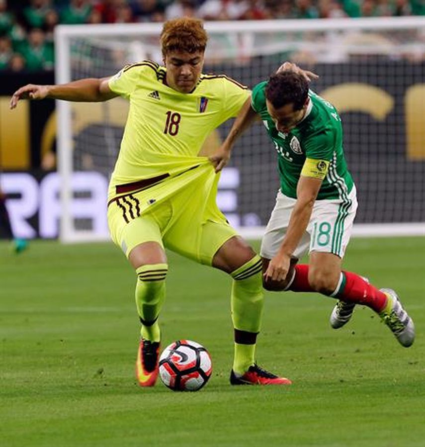 Adalberto Peñaranda (izquierda) de Venezuela disputa el balón con Andrés Guardado de México. (EFE)