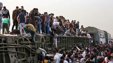 Decenas de personas se bajan del tren volcado en Egipto.&nbsp;