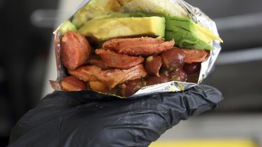 Un empleado muestra una arepa venezolana hecha con ingredientes colombianos en el restaurante de comida rápida Arepas Café en Bogotá, Colombia.