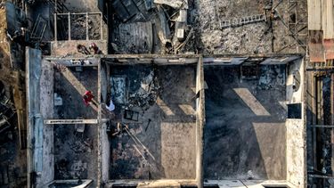 Un grupo de personas realiza labores de limpieza en medio de escombros en sus viviendas consumidas por las llamas de un incendio forestal en Viña del Mar, Chile.