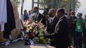 El primer ministro haitiano Ariel Henry (centro) coloca un ramo de flores en un monumento en memoria de las víctimas del sismo de 2010, en Puerto Príncipe, Haití, el miércoles 12 de enero de 2022.