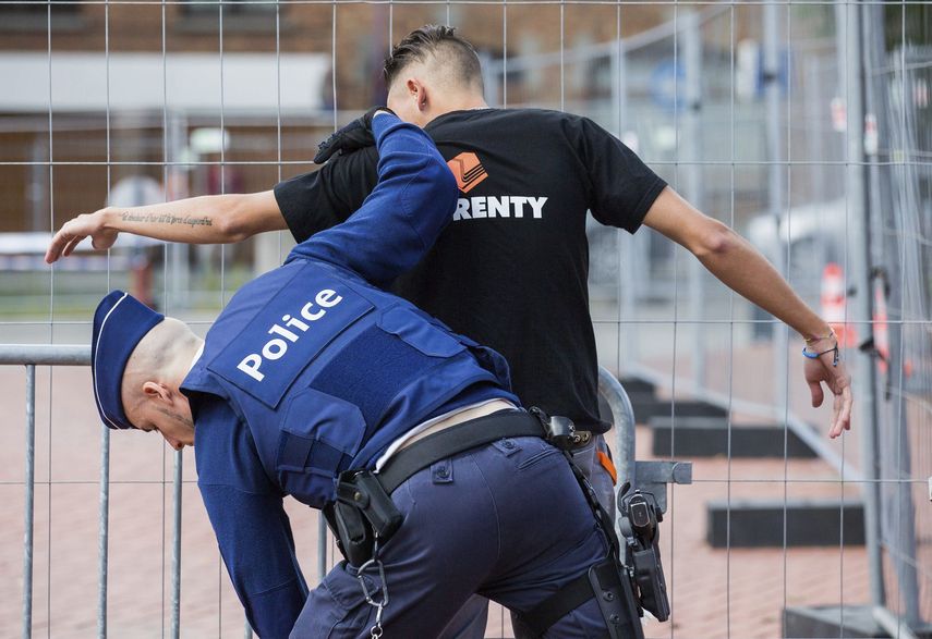 Un policía cachea a un hombre en el acceso del perímetro de seguridad de la comisaría de policía de Charleroi, Bélgica, este 9 de agosto de 2016.&nbsp;