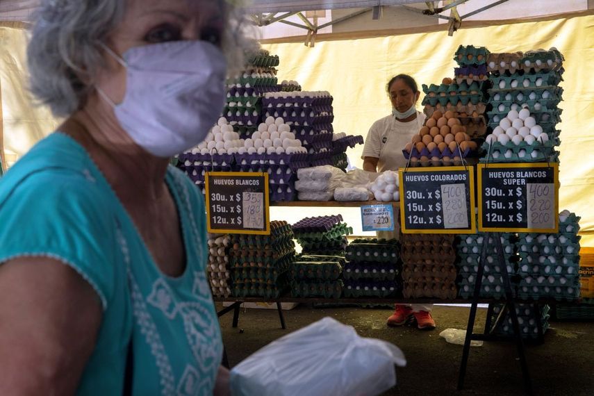 Inflación, una mujer se aleja después de comprar huevos en un mercado en Buenos Aires, Argentina.