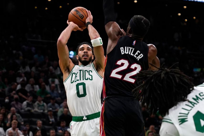 Jayson Tatum (derecha) de los Celtics de Boston dispara ante Jimmy Butler del Heat de Miami, en las finales de la Conferencia Este de la NBA