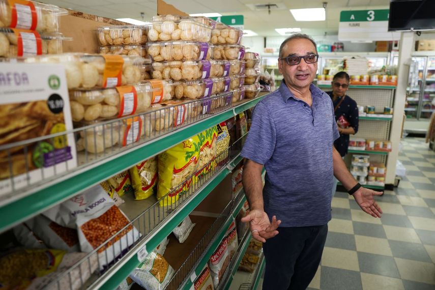 Dueño de un mercado en la India habla con periodistas sobre los aranceles.