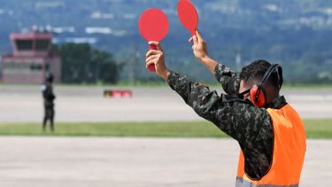 Un militar guía a un avión en la base militar de Estados Unidos, ubicada en Palmerola, Honduras