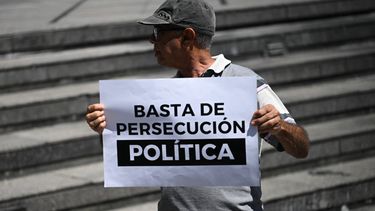 Un familiar de personas detenidas por el régimen de Nicolás Maduro tras las elecciones del 28 de julio de 2024 sostiene un cartel que dice basta de persecución política en una protesta en Caracas