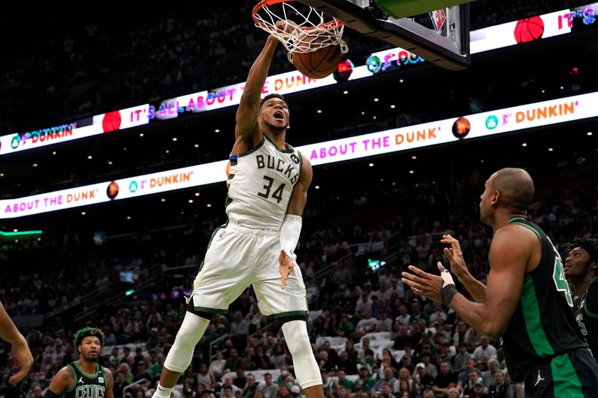El griego Giannis Antetokounmpo (34), de los Bucks de Milwaukee, retaca el balón frente a Marcus Smart, izquierda, y Al Horford, derecha, quien observa, en la primera mitad del Juego 1 de la serie de segunda ronda de playoffs de la NBA, en la Conferencia Este, el domingo 1 de mayo de 2022, en Boston. 