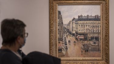 Una mujer mira la pintura impresionista Rue St.-Honore, Apres-Midi, Effet de Pluie (Calle Saint-Honoré por la tarde, efecto de lluvia) de Camille Pissarro de 1897 en el Museo Thyssen-Bornemisza en Madrid, España, el 22 de abril de 2022.