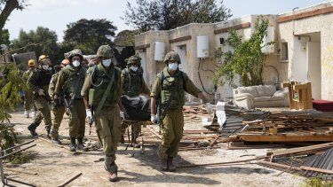 Soldados cargan cadáveres de israelíes asesinados en el kibutz Kfar Azza, Israel, el martes 10 de octubre de 2023. Militantes de Hamás invadieron Kfar Azza, el sábado, donde muchos israelíes fueron asesinados y hechos cautivos.&nbsp;