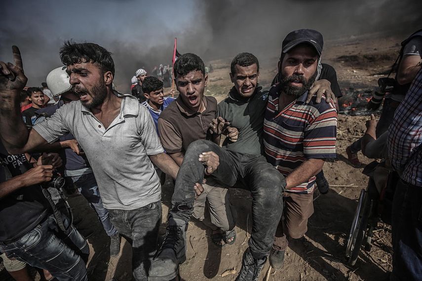 Palestinos llevan a un herido tras protestas este 8 de junio cerca de la Franja de Gaza. 