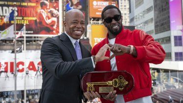 Esta foto proporcionada por la Oficina del la Alcaldía de Nueva York muestra al alcalde Eric Adams entregando la llave de la ciudad al artista de hip-hop Sean Diddy Combs en Times Square, Nueva York, el viernes 15 de septiembre de 2023.