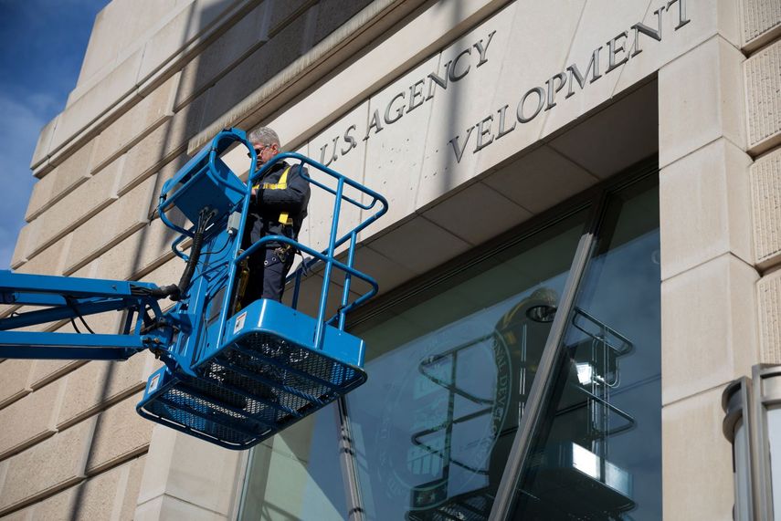 Un empleado de mantenimiento retira las siglas que identificaban a la Agencia Federal para el Desarrollo Internacional USAID de su edificio sede en Washington.