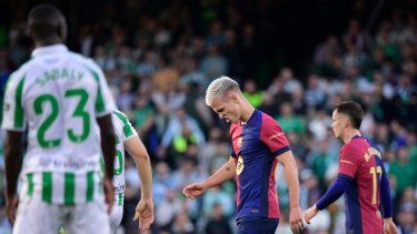 El delantero español del Barcelona, Daniel Olmo (C), reacciona después de caer al suelo durante un partido de fútbol de la liga española entre el Real Betis y el FC Barcelona en el estadio Benito Villamarín en Sevilla, el 7 de diciembre de 2024.