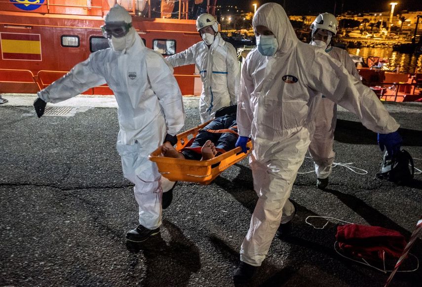 Un migrante es trasladado en camilla desde un barco de rescate en el puerto de Arguineguín, en la isla de Gran Canaria, España, el sábado 16 de enero de 2021.&nbsp;