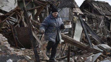 Inna, de 71 años, saca algunas de sus posesiones de entre los escombros de su casa, destruida por un dron ruso en un ataque a un vecindario residencial en Zaporiyia, Ucrania, el 28 de marzo de 2024. 