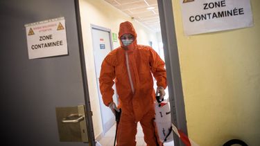 Para frenar la propagación del coronavirus en Francia, un trabajador de la salud usa un rociador para desinfectar el pasillo de un gimnasio utilizado como centro de descontaminación para trabajadores sanitarios y médicos a domicilio, el 6 de abril de 2020, en Trignac, oeste de ese país, es el día 21 de un encierro en Francia. 