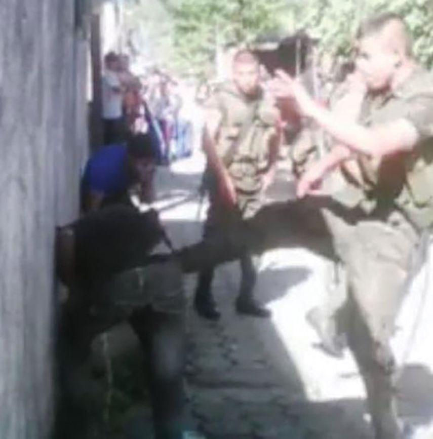 Uno de los militares patea al adolescente. (Captura de video)