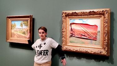 Esta fotografía tomada y publicada el 1 de junio de 2024 por el colectivo Riposte Alimentaire muestra a un miembro de Riposte Alimentaire con una camiseta que dice +4° the hell posando después de cubrir el cuadro de Claude Monet Les Coquelicots con una pegatina.  