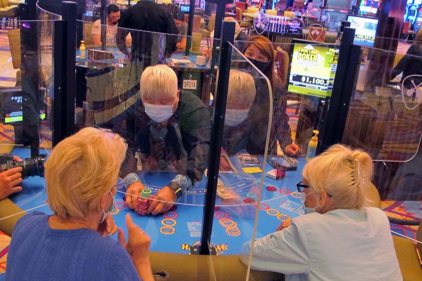 Barreras transparentes separan a los apostadores y el croupier en una mesa de cartas en el casino Hard Rock, Atlantic City, Nueva Jersey.