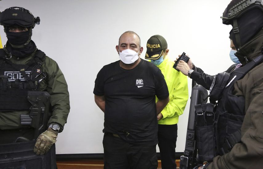 Foto proporcionada por la Oficina de Prensa de la Policía de Colombia, uno de los narcotraficantes más buscados del país, Dairo Antonio Úsuga, alias Otoniel, es esposado a su llegada a Bogotá, Colombia, el sábado 23 de octubre de 2021.