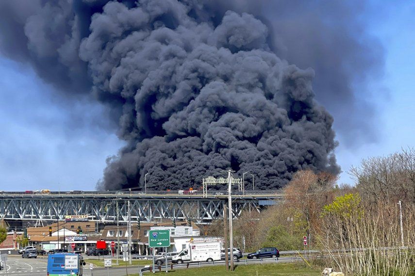 Gruesas columnas de humo se alzan de un incendio provocado por el choque entre un camión cisterna de combustibles y un auto en el puente Gold Star Memorial en Groton, Connecticut, viernes 21 de abril de 2023.&nbsp;
