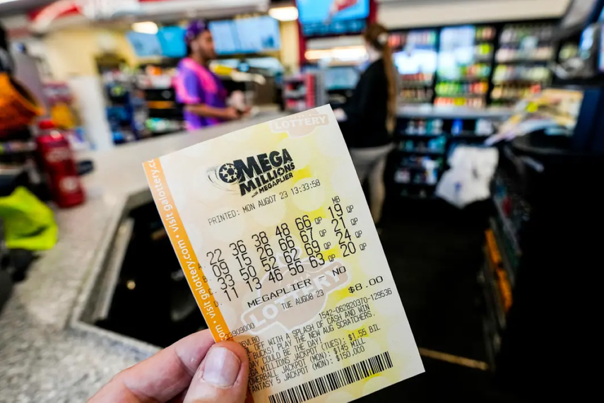 Una persona sostiene un ticket del Mega Millions.