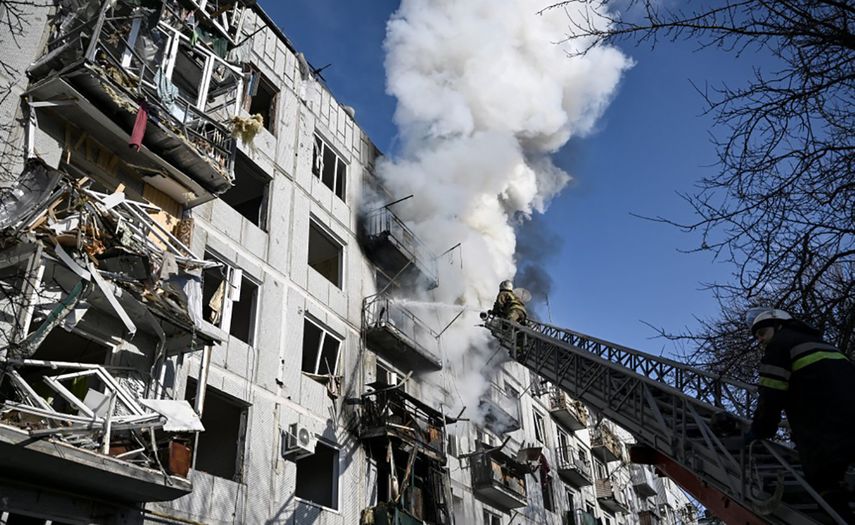 Bomberos tratan de apagar fuego en un edificio de apartamentos en Chuguiv, en el noreste de Ucrania.