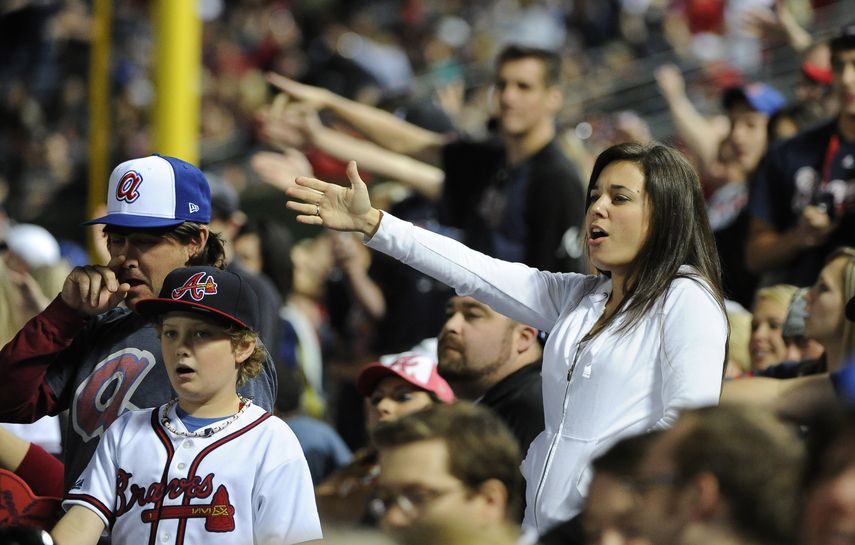 En esta imagen del 2 de mayo de 2014, aficionados de los Bravos de Atlanta alientan al equipo con el cantico del tomahawk chop en la novena entrada del juego ante los Gigantes de San Francisco, en Atlanta.&nbsp;