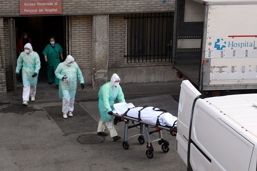 Trabajadores de salud trasladan el cad&aacute;ver de uno de los fallecidos por el coronavirus COVID-19 en el hospital&nbsp;Gregorio Maranon, en Madrid, Espa&ntilde;a, el 25 de marzo de 2020.
