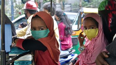 Los niños que viajan con sus padres en un auto rickshaw usan una máscara facial como medida preventiva contra el coronavirus COVID-19, en Bangalore, el 27 de julio de 2020.