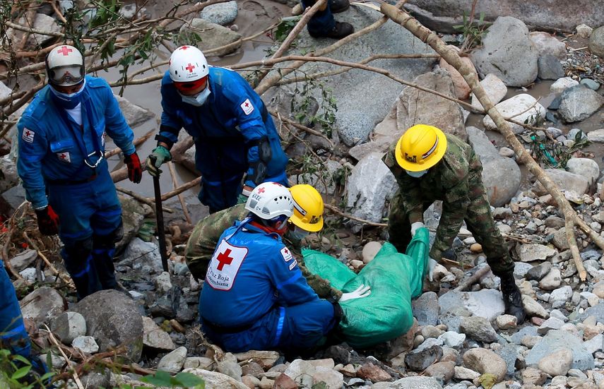 Miembros de la Cruz Roja y el Ejército de Colombia recuperan un cuerpo.